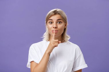 Çekici, yaratıcı, şık, bronz tenli, açık tenli, kameraya şşşş yapan heyecanlı bakışlı, harika bir fikir uyduruyor. Saklamak ve mor duvarın üzerinde gizli poz vermek.