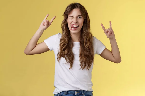 Awesome party having fun. Daring attractive carefree girl enjoy excellent event show rock-n-roll heavy metal gesture mimicking funny expressions wink stick tongue stand yellow background amused — Stock Photo, Image