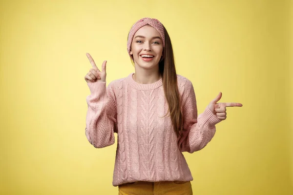 Выбирай, что хочешь. Харизматичная жизнерадостная молодая студентка в повязке на голове, свитер, указывающий вверх, указывающий на правую улыбающуюся милую, рекламирующий возможности и выбор над белой стеной — стоковое фото