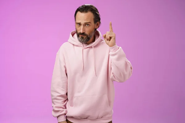 Strict serious-looking stylish bearded father teaching scolding teenage son raising index finger frowning displeased disappointed bad child behaviour, make statement, standing purple background — Stock Photo, Image