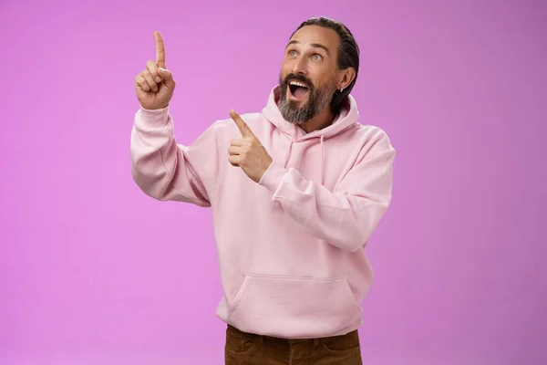 Modische gut aussehende faszinierte ältere bärtige Mann graue Haare schauen erstaunt zeigt Blick oben links Ecke sehen Wunder unglaublich atemberaubende herrliche Aussicht, stehend lila Hintergrund — Stockfoto