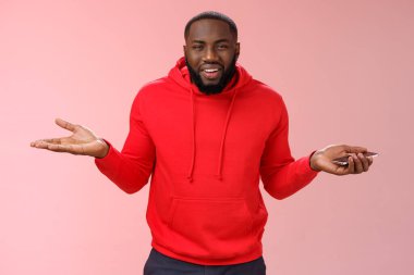 Kimin umrunda. Umursamaz, umursamaz, soğukkanlı, yakışıklı, afro-amerikalı, omuz silken, bihaber, dikkatsiz, kafası karışık, akıllı telefonu tutan bir adamın portresi.