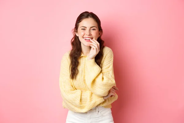 Imagem de jovem mulher atraente rindo, olhando para a câmera algo engraçado, de pé alegre contra fundo rosa — Fotografia de Stock