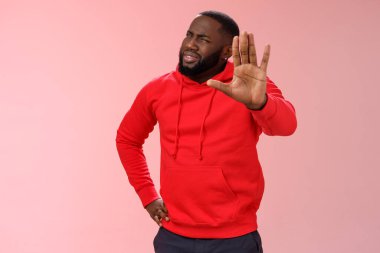 Bekle, orada dur. Kafası karışmış afro-amerikan bir adam sorgulanıyor elini kaldırıyor jestleri kesin tartışmayı dinleyin saçma sapan şeyler duyun pembe arka plan