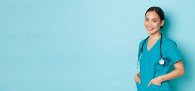 Covid-19, sosyal uzaklık ve koronavirüs salgını konsepti. Profesyonel özgüvenli, güzel Asyalı kadın doktor, steteskoplu hemşire geniş bir gülümsemeyle kliniğe hoş geldiniz.