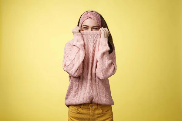 Cute playful young girl hiding in sweater peeking and squinting flirty over top of cloth pulling collar on nose, fooling around having fun happily, being in positive good mood, warming-up on cold day — Stock Photo, Image