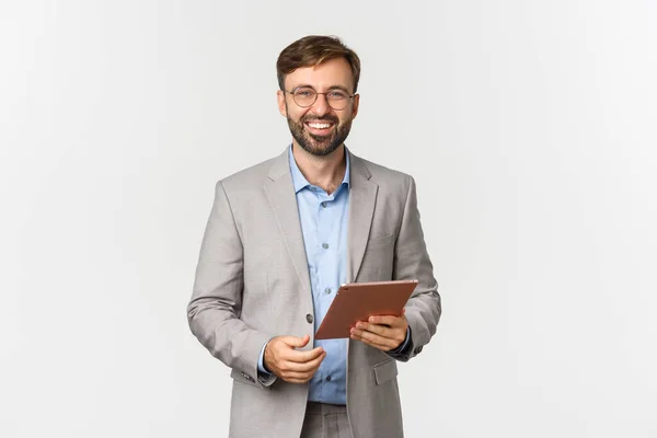 Retrato de empresário bem sucedido e confiante com tablet digital, sorrindo para a câmera, em pé sobre fundo branco — Fotografia de Stock