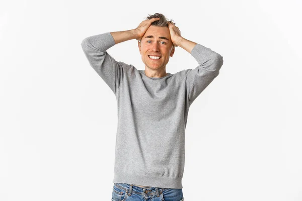 Imagen de un hombre frustrado de mediana edad, agarrado de la cabeza y mirando angustiado, perdiendo algo, de pie sobre un fondo blanco — Foto de Stock