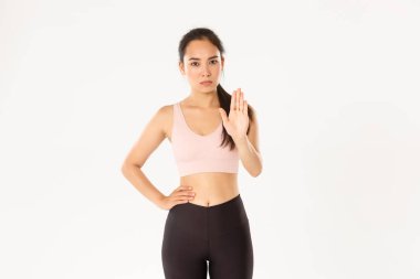 Spor, refah ve aktif yaşam tarzı konsepti. Ciddi ve hoşnutsuz Asyalı sporcu kadın dur jesti, kadın fitness koçu ya da eğitmen uyarısı, kısıtlı spor salonu müşterisi, beyaz arka plan