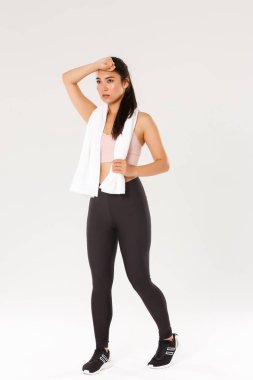 Spor, spor salonu ve sağlıklı vücut konsepti. Tam boy ciddi ve odaklanmış bayan atlet eğitimi, ter silme ve yorgun görünme ama egzersiz sırasında motive olma, egzersiz yapma