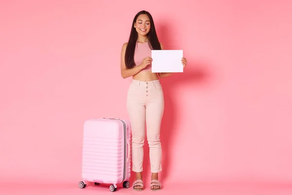 Reisen, Urlaub und Urlaubskonzept. Asiatische Austauschstudentin kommt mit Koffer, Papierschnipsel in der Hand und lächelnd auf der Suche nach Gastfamilie am Flughafen an — Stockfoto