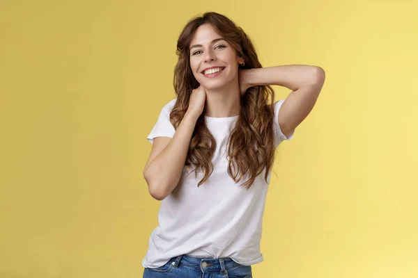 Alegre carismático boa aparência encaracolado mulher esticando posando fundo amarelo toque pescoço flerte sorrindo relaxante perfeito verão férias reserva fim de semana viagem finalmente descansar sob o sol — Fotografia de Stock