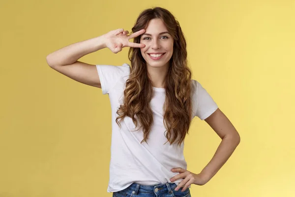 Alegre positivo bonito menina encaracolado mostrar sinal de paz encantado desfrutar da juventude ter férias de verão perfeito determinado férias viagem de descanso sorrindo amplamente ficar confiante fundo amarelo — Fotografia de Stock