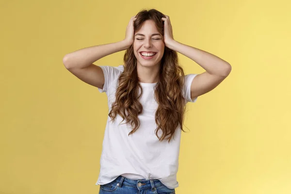 Alegre feliz entusiasta boa aparência menina receber inacreditável incrível oportunidade viagem verão férias no exterior agarrar a cabeça fechar os olhos sorrindo feliz triunfando otimista fundo amarelo — Fotografia de Stock