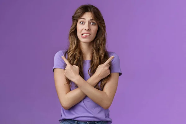Perplexed timid hesitant worried girlfriend afraid making bad choice cross hands pointing sideways indicating left right perplexed decide frowning pull hesitant face asking advice purple background — Stock Photo, Image