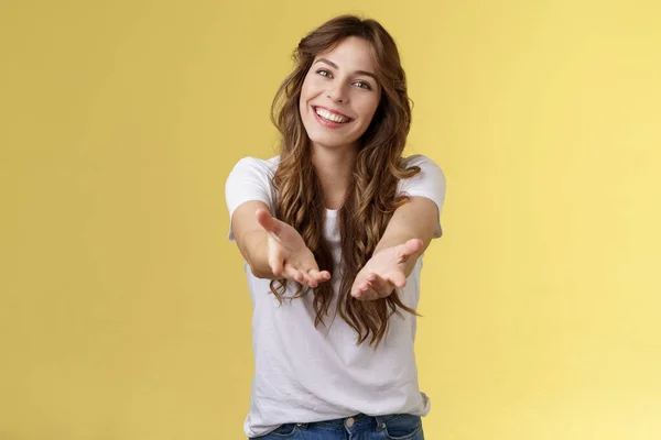 Aproxima-te, segura a minha mão. Alegre adorável carismático concurso mulher estender braços para a frente câmera quer segurar receber charmoso dom inclinação cabeça sorrindo satisfeito grato stand amarelo fundo — Fotografia de Stock