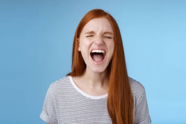 Girl screaming out loud showing attitude take out stress being fed up complaining hursh life shouting closed eyes yelling pissed standing bothered distressed blue background