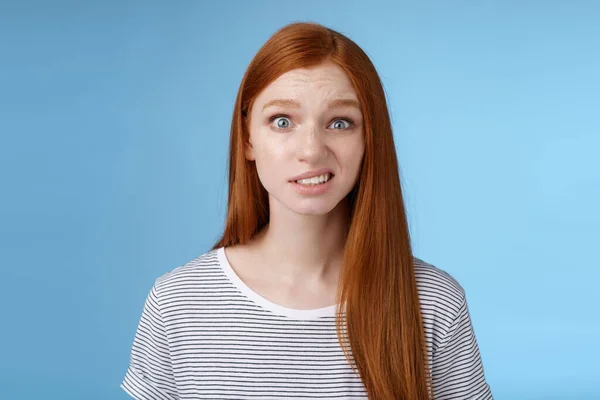 Confused stunned young doubtful redhead girl look full disbelief smirking unsure frowning cringing hesitant standing disappointed uncertain, feel awkward hearing embarrassing story — Stock Photo, Image