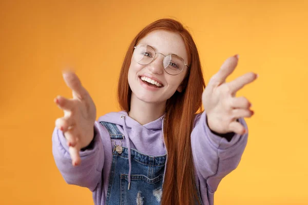 Come here let hold. Attractive silly friendly happy smiling redhead woman stretch arms camera grab product wanna tight friendship hugs grinning embracing cuddling besties, orange background — Stock Photo, Image