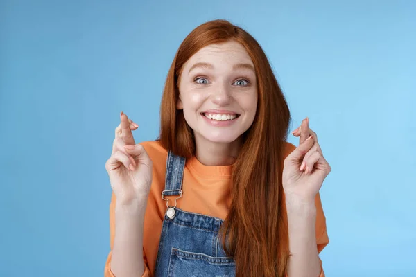 兴奋的情绪快乐的红头发的女孩笑着乐观的盯着惊讶的激动的手指相信梦想成真许愿只期待好消息，蓝色背景 — 图库照片