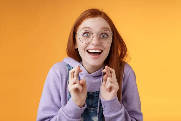 Sueño chica sorprendida se hizo realidad celebrando de pie divertidos dedos cruzados excitados buena suerte deseo cumplido sonriente emotivo emocionado finalmente ganar recibir buenas noticias optimista naranja optimista fondo — Foto de Stock