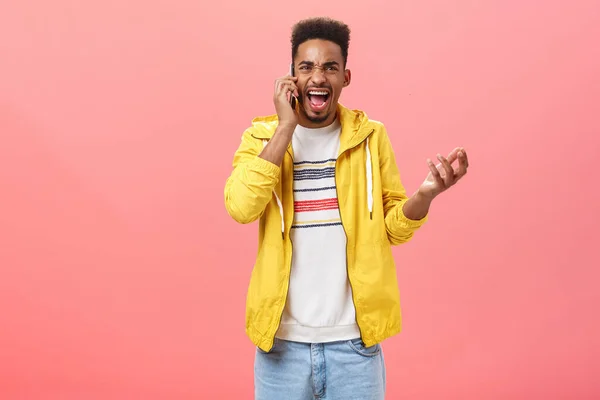 Guy fighting having rough argument with girlfriend via phone call yelling in smartphone gesturing from anger and rage holding device near ear shouting pissed over pink background — 图库照片