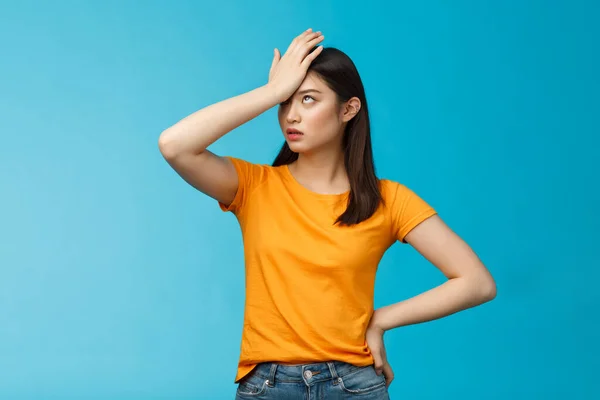 Annoyed arrogant asian girl punch forehead make facepalm sign, roll eyelids irritated pissed, cannot stand lame talks look disappointed ingorant, unwilling to listen, stand blue background — Stock fotografie