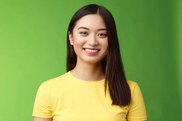 Optimiste mignonne insouciante asiatique fille prenant soin de l'état de la peau, souriant satisfait sourire heureux, profiter de conversation drôle sortante, stand green background upbeat, communiquer agréablement — Photo