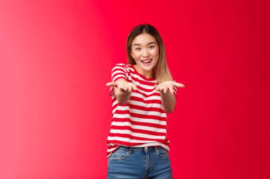 Hepsi senin için. Nazik görünümlü, minnettar, sarışın Asyalı kız, avuç içi kamerasını işaret ediyor, arkadaşını tebrik ediyor, erkek arkadaşına hediyesini veriyor, gülümsüyor, kız arkadaşını cesaretlendiriyor, kıyafetine bak diyor.