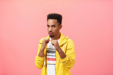 Savaşa her zaman hazırım. Kendine güvenen, şık, esmer, sakallı, afro saçlı, yumruklarını kaldıran cesur ve kendine güvenen erkek portresi.