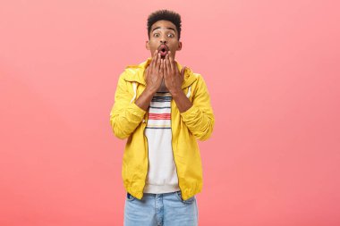 Adam şaşırtıcı bir haber buldu. Dilsiz Afro-Amerikan yetişkin erkek trend sarı ceketli, kıvrık dudaklı avuç içleri açık bir şekilde kameraya bakıyordu.