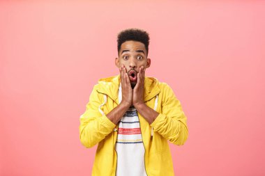 Şık giyinmiş, sakallı, kıvırcık saçlı, ağzı açık, dudakları dudaklarının yanında nefes nefese kalmış, pembe arka planda hayretler içinde kalmış Afro-Amerikan bir adamın şaşkınlığına uğradım.