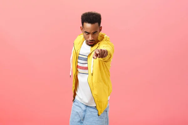 You will regret this. Portrait of threatening angry and pissed dangerous african american young man looking from under forehead with disdain and rage pointing at camera blaming someone over pink wall — Stockfoto