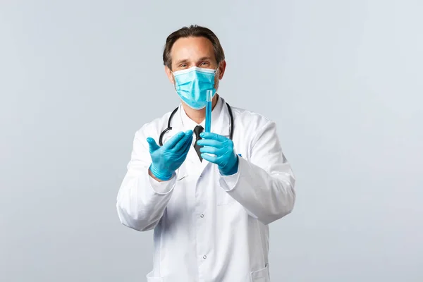 Covid-19: 바이러스 예방, 의료 종사자 및 예방 개념. 의료 마스크와 백신 샘플이든 시험관을 가리키는 장갑을 낀 만족 스러운 미소 의사, 좋은 결과에 만족 — 스톡 사진