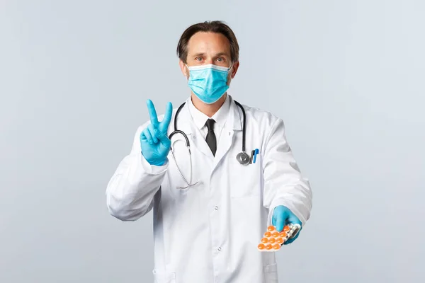 Covid-19: 바이러스 예방, 의료 종사자 및 예방 개념. 의료용 마스크와 장갑 처방을 받은 의사는 하루에 두 번씩 약을 복용하고 두 번씩 약을 보여 줍니다. — 스톡 사진
