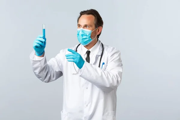 Covid-19: 바이러스 예방, 의료 종사자 및 예방 개념. 클리닉에서 과도 한 의사가 코로나 바이러스 백신을 개발하고, 의료 마스크와 장갑을 착용하고 시험관에서 흥분 한 모습을 하고 있습니다. — 스톡 사진