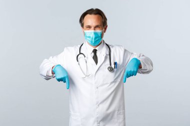 Covid-19, virüsü önleme, sağlık çalışanları ve aşı konsepti. Tıbbi maskeli ve eldivenli hoş bir doktor tavsiye verir, tavsiye eder, reklam önerir, pankartı işaret eder.