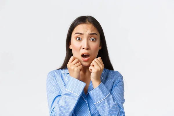 Detailní záběr vystrašené asijské ženy v panice stojící v pyžamu beze slov, reagující na děsivou a šokující scénu, vypadající vyděšeně, třesoucí se strachem nad bílým pozadím — Stock fotografie