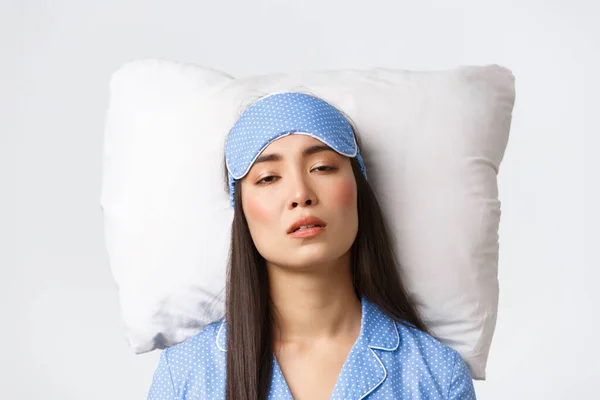 Close-up of exhausted sleepy asian girl looking tired as lying in bed on pillow, woman with insomnia problems have no sleep at night. Female waking up with hangover after sleepover party — Stock Photo, Image