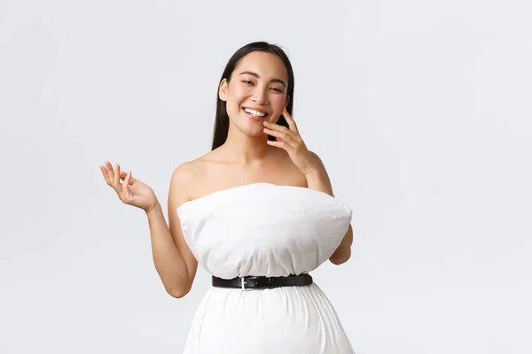 Koncept krásy, módy a sociálních médií. Pěkný šťastný asijské žena smích a show-off její nové oblečení z polštáře a pásku, pózování v polštáři šaty přes bílé pozadí — Stock fotografie