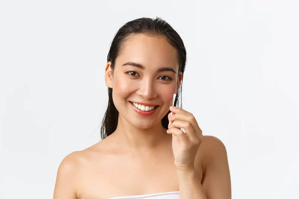 Skincare, women beauty, hygiene and personal care concept. Close-up of beautiful asian girl standing naked in bathroom or shower, holding cotton buds, swabs for ears, standing white background — Stock Photo, Image
