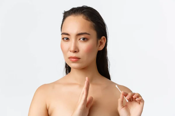 Skincare, women beauty, hygiene and personal care concept. Displeased serious-looking asian female standing naked and turn away from cotton bud, make stop or disapprove gesture, white background — Stock Photo, Image