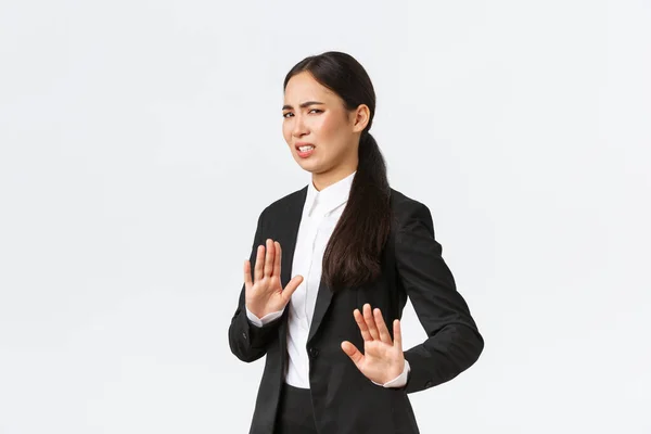 Displeased asian businesswoman avoiding risky suggestions, shaking hands in refusal, rejecting disgusting strange offer. Saleswoman grimacing from aversion and step away, white background — Stock Photo, Image
