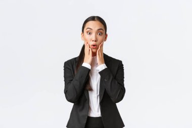 Şaşırmış ve şaşırmış Asyalı kadın iş kadını büyük haberleri duyuyor. Satıcı kadın şok edici haberler alıyor, takım elbise içinde kameraya bakıyor, iş ortaklarıyla büyük bir anlaşma imzalıyor.