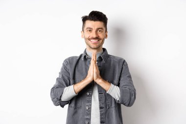 Teşekkür ederim. Gülümseyen dost canlısı adam şükranlarını sunuyor, yardım için minnettar, beyaz arka planda mutlu duruyor.