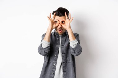 Komik adam el dürbününden bakıyor, muhteşem tanıtımlara bakıyor, 