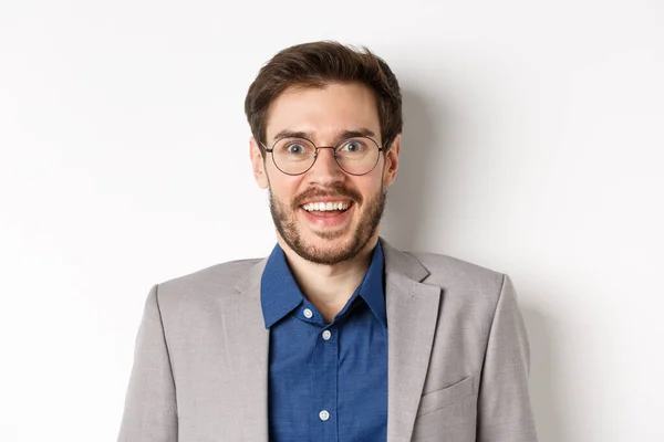 Glada europeiska mannen i glasögon och kostym leende upphetsad, tittar på kamera med förvånad glad ansikte, vit bakgrund — Stockfoto