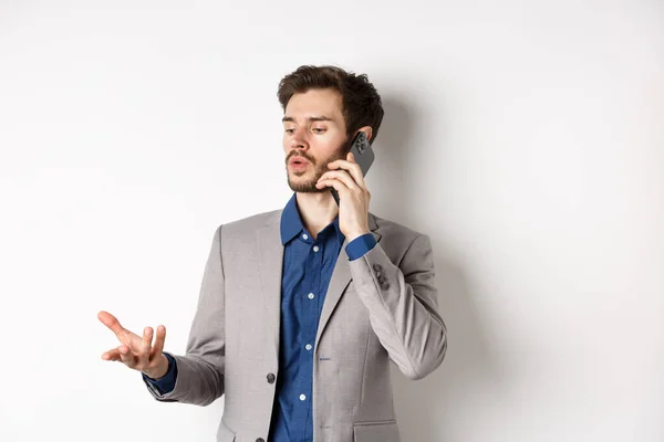 Handsome businessman having business call on phone, gesturing while talking on mobile, having conversation, white background — Stock Photo, Image