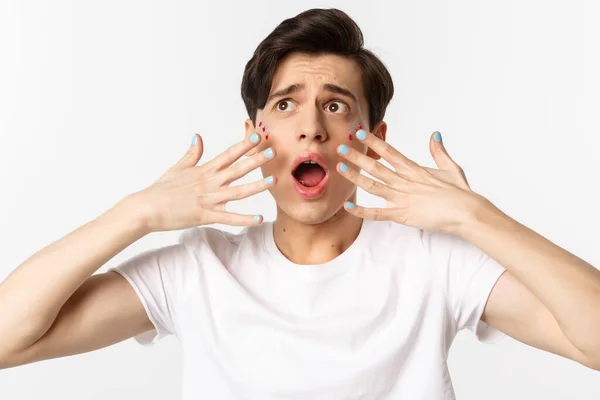 People, lgbtq and beauty concept. Close-up of gay man panicking, showing nail polish on hands, looking alarmed and worried, standing over white background — Stock Photo, Image