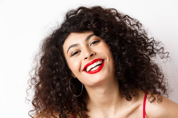 Close-up portrait of happy beautiful woman with curly hair and red lip, smiling white teeth, express happiness and joy